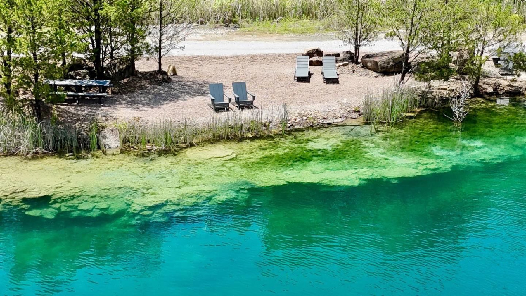 Emerald spring water along the rocky shoreline